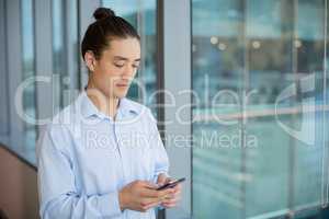 Business executive using on mobile phone in corridor