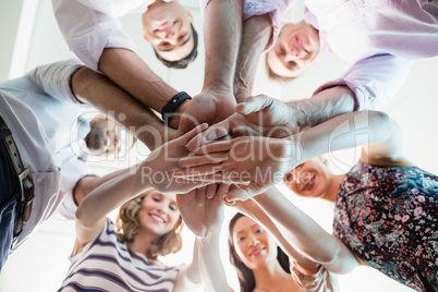 Portrait of smiling business colleagues with their hands stacked