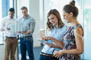 Smiling business colleagues using digital tablet
