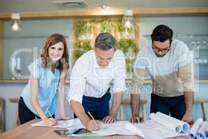 Architects working over blueprint in conference room