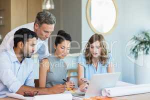 Architects discussing over laptop in conference room