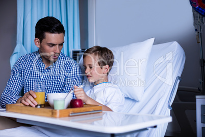 Father feeding breakfast to his son