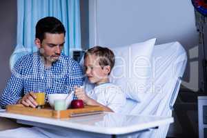 Father feeding breakfast to his son