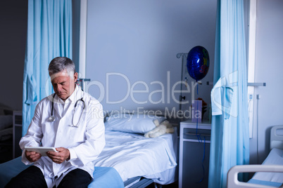 Doctor using digital tablet in ward