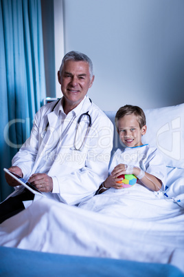 Doctor showing medical report in digital tablet to patient in hospital