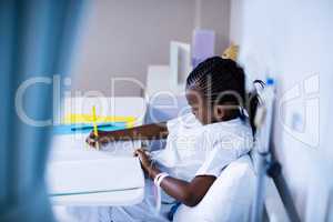 Patient writing on the book while sitting at hospital