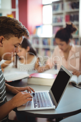 Attentive student using laptop in library