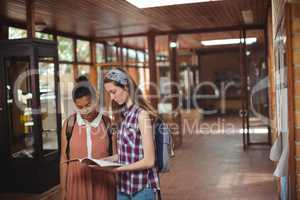 School kids reading books in corridor