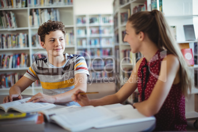 Classmates interacting while doing homework in library