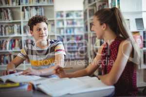 Classmates interacting while doing homework in library