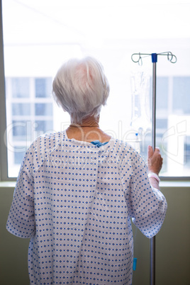 Thoughtful senior patient standing at hospital