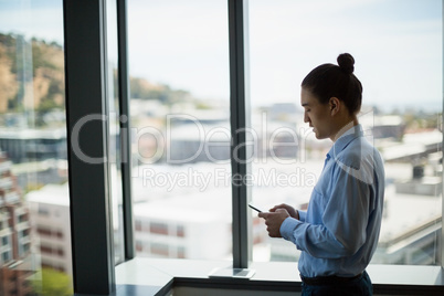 Business executive using on mobile phone in corridor