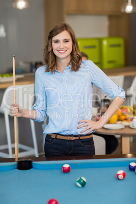 Portrait of smiling business executive playing pool
