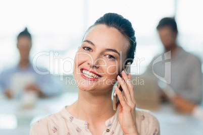 Beautiful business executive talking on her mobile phone in conference room