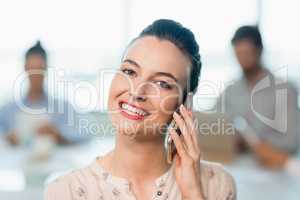 Beautiful business executive talking on her mobile phone in conference room