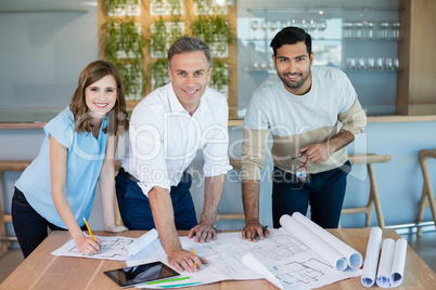 Smiling architects working over blueprint in conference room
