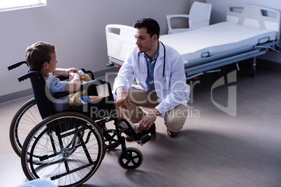 Male doctor interacting with child patient in ward