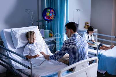 Father consoling his son during visit in ward