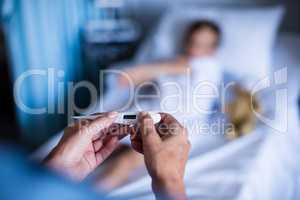 Female doctor holding thermometer at hospital