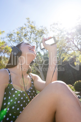Happy woman listening to music on mobile phone
