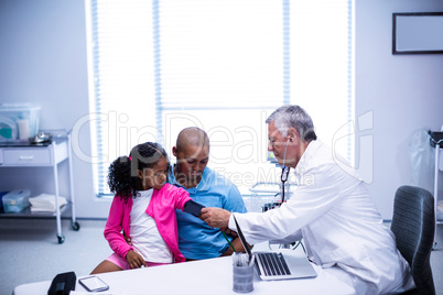 Doctor checking patient blood pressure