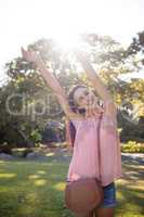 Happy woman standing in the park with her hands raised