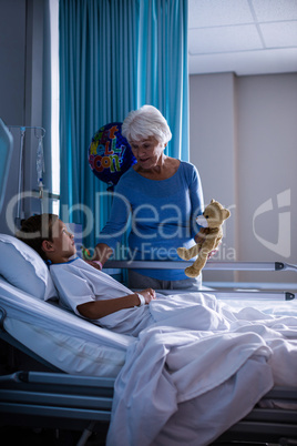 Grandmother showing teddy bear to grandson