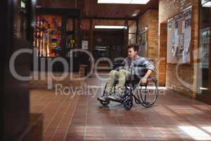 Disabled schoolboy on wheelchair in corridor at school