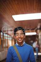 Portrait of smiling schoolboy standing in corridor