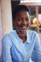 Happy schoolgirl sitting in school campus