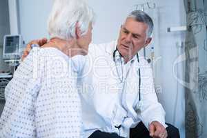 Doctor consoling senior patient