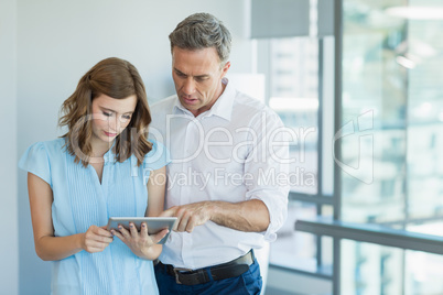 Business executives discussing over digital tablet