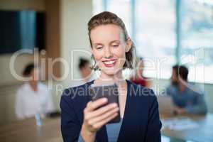 Business executive using her mobile phone in conference room