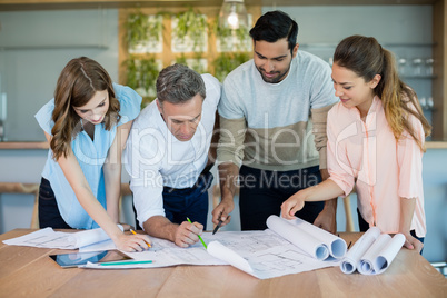 Architects working over blueprint in conference room