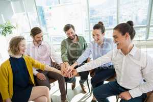 Business executives with their hands stacked while sitting