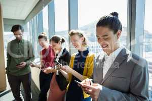 Business executives smiling while using electronic devices