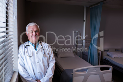 Portrait of male doctor leaning in ward