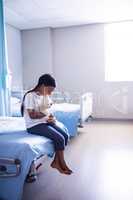 Patient sitting on bed with teddy bear