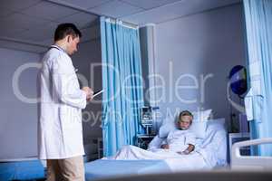 Doctor using digital tablet in ward