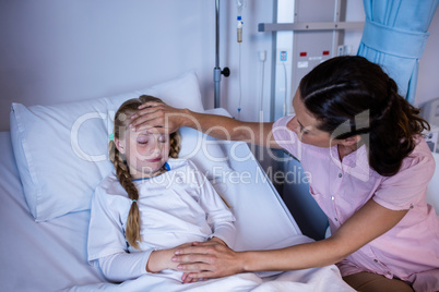 Female doctor checking patient fever in ward