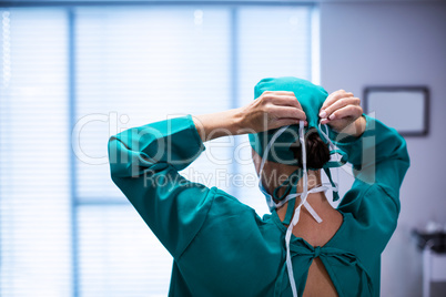 Rear view of female surgeon wearing surgical mask in operation theater