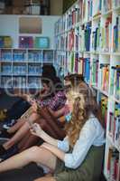 Students using mobile phone in library