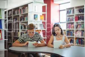 Students using digital tablet in library