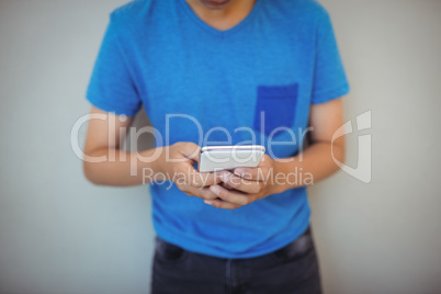 Schoolboy using mobile phone in corridor at school