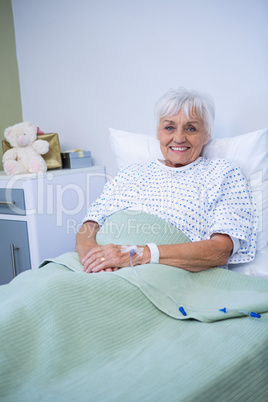 Portrait of smiling senior patient on bed