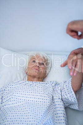 Doctor examining senior patient in ward