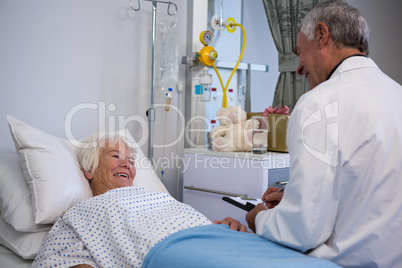 Doctor discussing medical report with senior patient