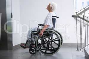 Disabled senior patient on wheelchair in hospital corridor