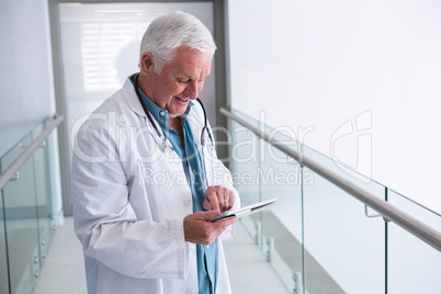 Doctor using a digital tablet in the passageway