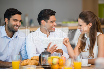 Business colleagues interacting with each other while having breakfast
